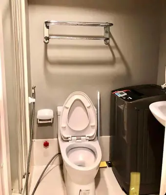 a small bathroom with a toilet and a sink at Cosy Light Residences Unit Staycation in Manila