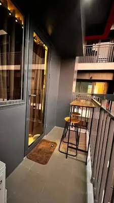 a small balcony with a table and a stool at M&B Staycation in Manila