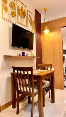 a dining room table with two chairs and a tv at M&B Staycation in Manila