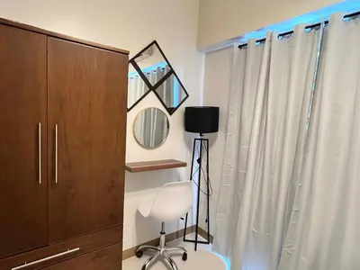 a room with a mirror and a chair and a cabinet at M&B Staycation in Manila