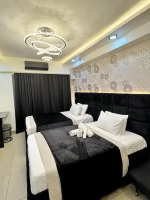 a hotel room with two beds and a chandelier at M&M Condostay at Shore 2 Residences Tower 3 in Manila