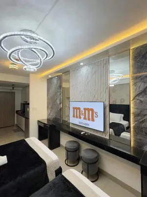 a hotel room with two beds and a television at M&M Condostay at Shore 2 Residences Tower 3 in Manila