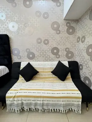 a bedroom with a bed with black pillows on it at M&M Condostay at Shore 2 Residences Tower 3 in Manila