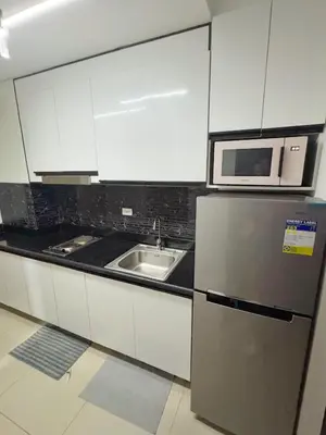 a kitchen with a stainless steel refrigerator and a microwave at M&M Condostay at Shore 2 Residences Tower 3 in Manila