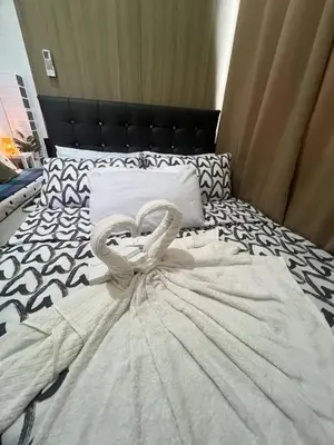a white bed with a heart decoration on it at Seaside Serenity in Manila