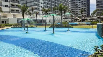a large swimming pool with umbrellas on top of it at Amazing View 2br MOA, 98 sqm XBOX 200mbps, Printer in Manila