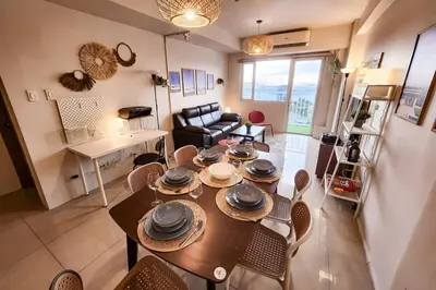 a living room with a dining room table and chairs at Amazing View 2br MOA, 98 sqm XBOX 200mbps, Printer in Manila