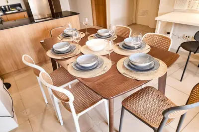 a wooden table with chairs and plates on it at Amazing View 2br MOA, 98 sqm XBOX 200mbps, Printer in Manila