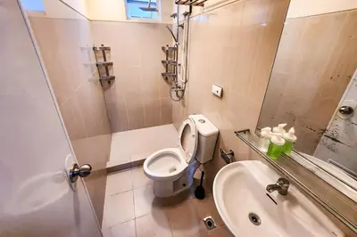 a bathroom with a toilet and a shower and a sink at Lush 2br 98sqm MOA 200mbps Netflix XBOX Printer in Manila