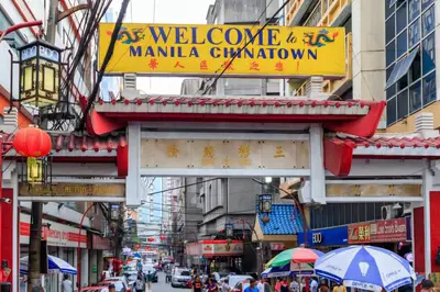 a busy city street with a sign for a manila chinatown at Lush 2br 98sqm MOA 200mbps Netflix XBOX Printer in Manila