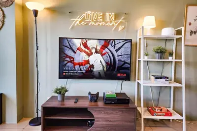 a living room with a flat screen tv on a wall at Lush 2br 98sqm MOA 200mbps Netflix XBOX Printer in Manila