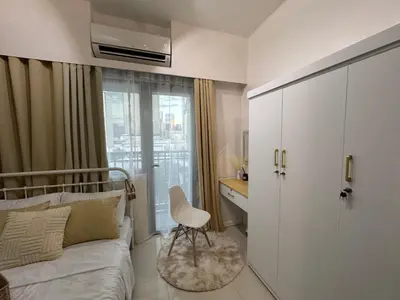 a bedroom with a bed and a chair in it at Fame residences in Manila