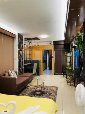 a living room with a couch and a glass table at Shell Residences with MOA View near NAIA - Aiza's Place in Manila