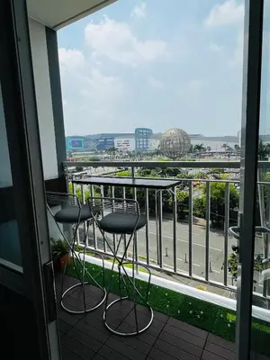 a balcony with two chairs and a table and a view at Shell Residences with MOA View near NAIA - Aiza's Place in Manila