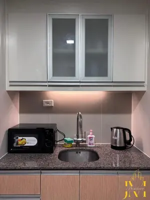 a kitchen counter with a sink and a microwave at Cozy & Aesthetic 1 BR in BGC in Manila
