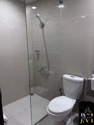 a bathroom with a toilet and a glass shower at Cozy & Aesthetic 1 BR in BGC in Manila