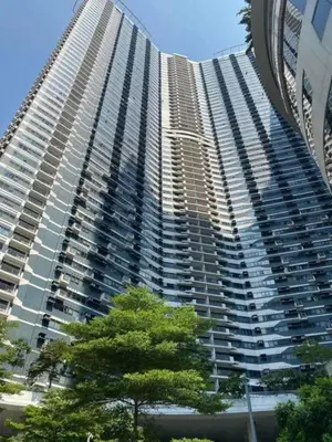 a tall building with a tree in front of it at 1LDK Air Studio in Makati City in Manila