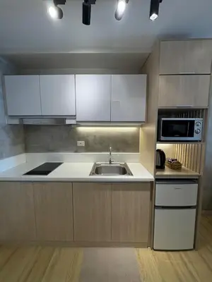 a kitchen with a sink and a microwave at 1LDK Air Studio in Makati City in Manila