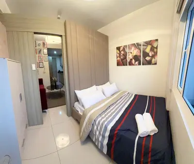 a small bedroom with a bed and a mirror at LALAROOMS - with Manila Bay Sunset View in Manila