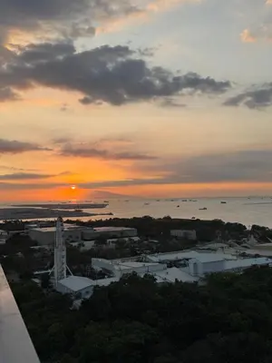 a sunset over a city with a bridge at LALAROOMS - with Manila Bay Sunset View in Manila