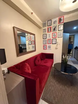 a living room with a red couch and a mirror at LALAROOMS - with Manila Bay Sunset View in Manila