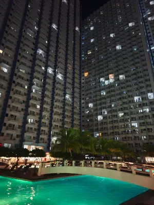 a pool in front of a large building at night at City Staycation Condo-SM Jazz in Manila