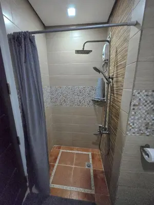 a bathroom with a shower with a shower curtain at Central BGC - Spacious Modern 2 bedrooms 2 bathrooms with Balcony in Manila