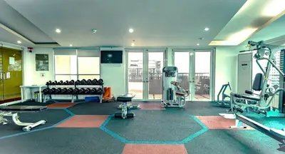 a gym with treadmills and machines in a room at Central BGC - Spacious Modern 2 bedrooms 2 bathrooms with Balcony in Manila