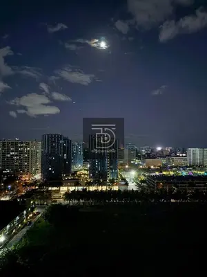 a view of a city at night with the moon at Shore 3 Tower 1 Condo staycation near MOA - DT in Manila
