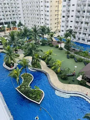 an aerial view of a resort with palm trees and a pool at The Cozy Corner in Manila