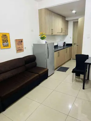a living room with a couch and a kitchen at The Cozy Corner in Manila