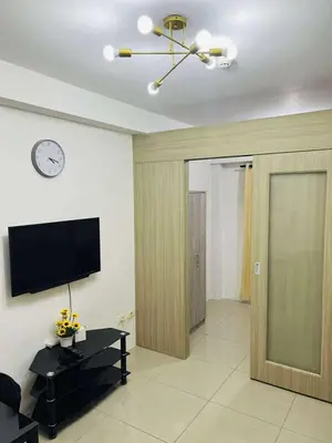 a living room with a sliding door and a television at The Cozy Corner in Manila