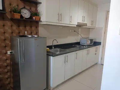 a kitchen with a sink and a refrigerator at Sea Reaidence Tower E in Manila