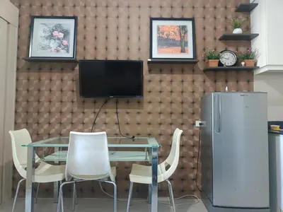 a dining room with a glass table and a refrigerator at Sea Reaidence Tower E in Manila