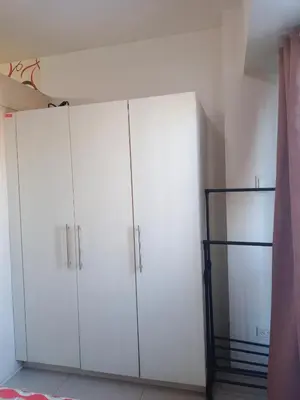 a room with white cabinets and a shelf at Sea Residence Tower EF in Manila