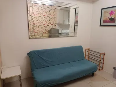 a blue couch in a room with a mirror at Sea Residence Tower EF in Manila