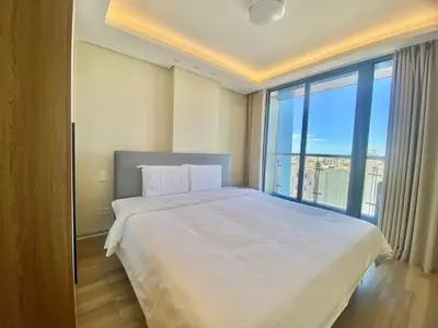 a bedroom with a large bed with a large window at City Center Executive Hotel-Near Manila Airport and PITX in Manila