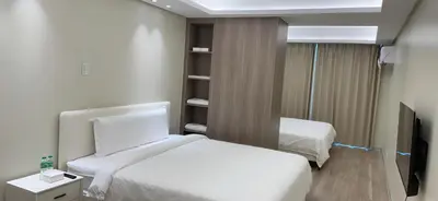 a bedroom with two beds and a tv in it at City Center Executive Hotel-Near Manila Airport and PITX in Manila