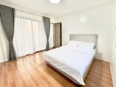 a bedroom with a white bed and large windows at CASA GUADA - Villa & Pool House Staycation in Postema