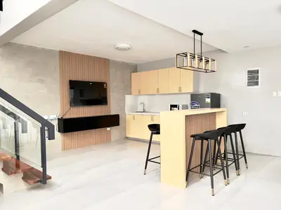 a kitchen with a counter and stools at CASA GUADA - Villa & Pool House Staycation in Postema