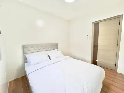 a white bed in a white bedroom with a door at CASA GUADA - Villa & Pool House Staycation in Postema