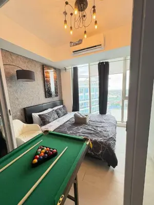a bedroom with a pool table in front of a bed at Celestial Sphere Staycation at Azure Urban Resort Residences in Manila