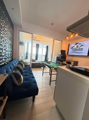 a living room with a couch and a ping pong table at Celestial Sphere Staycation at Azure Urban Resort Residences in Manila
