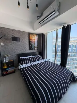 a bedroom with a striped bed and a large window at Celestial Sphere Staycation at Azure Urban Resort Residences in Manila