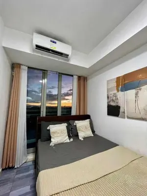 a bedroom with a bed with a air conditioner on the ceiling at Aerith's Haven Azurecation in Manila
