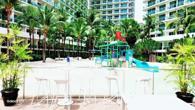 a playground in the middle of a park with palm trees at Aerith's Haven Azurecation in Manila