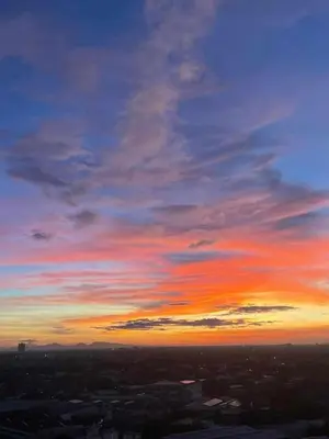 a sunset in the sky with a city at Aerith's Haven Azurecation in Manila