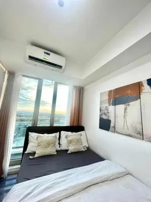 a bedroom with a bed and a large window at Aerith's Haven Azurecation in Manila