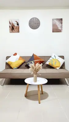 a couch with pillows and a table in a room at Casa de Porch in Manila