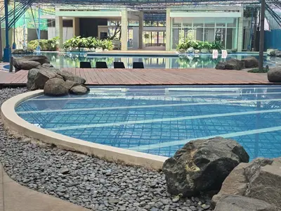 a swimming pool in a building with rocks around it at Casa de Porch in Manila